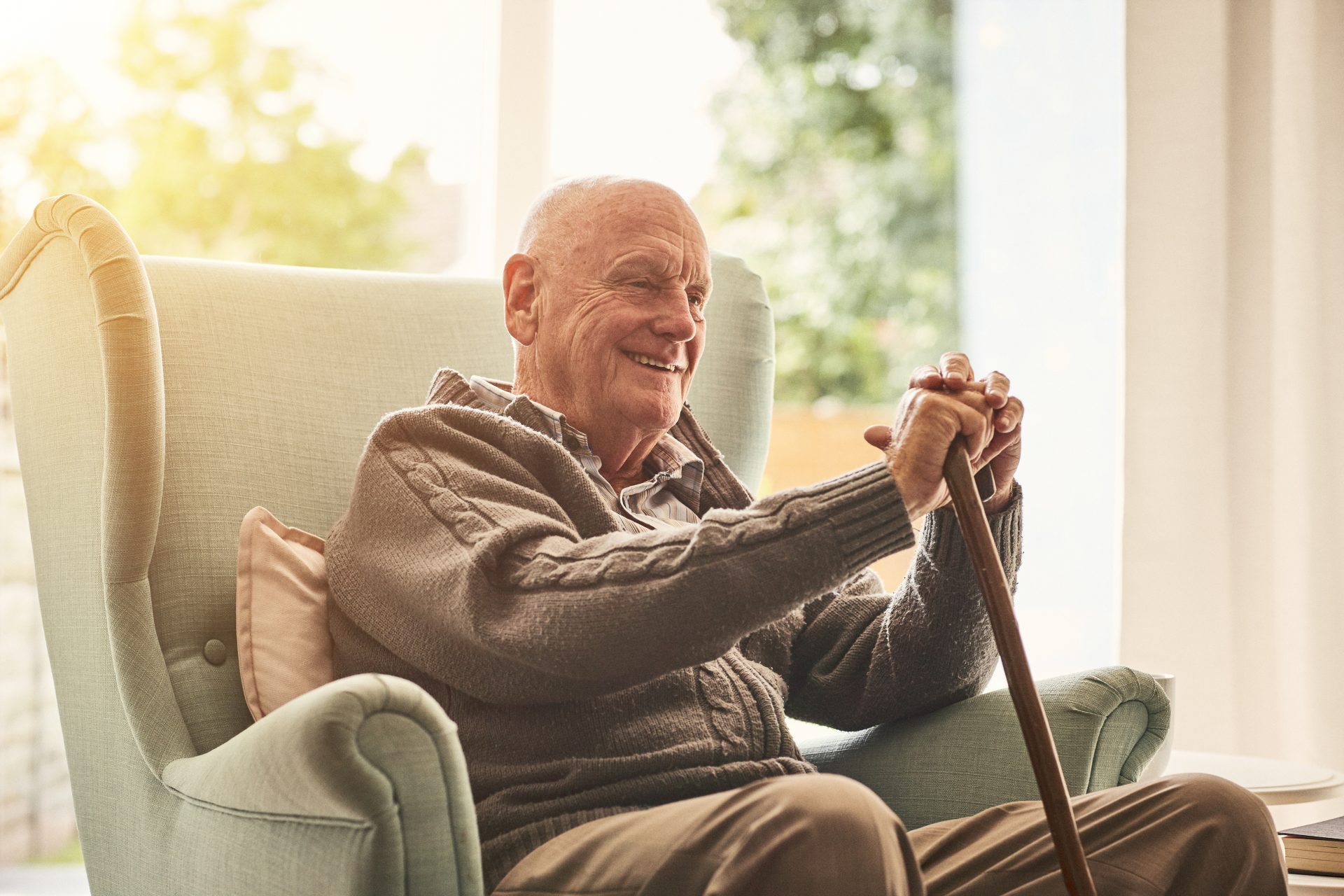 man sitting in chair with cane