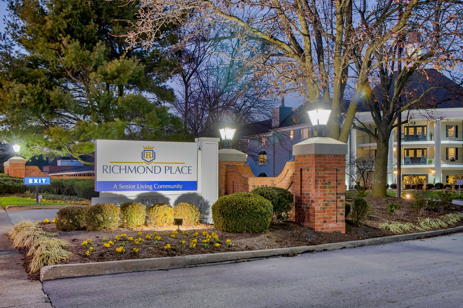 Entrance sign of Richmond Place, a senior living community, illuminated in the evening.