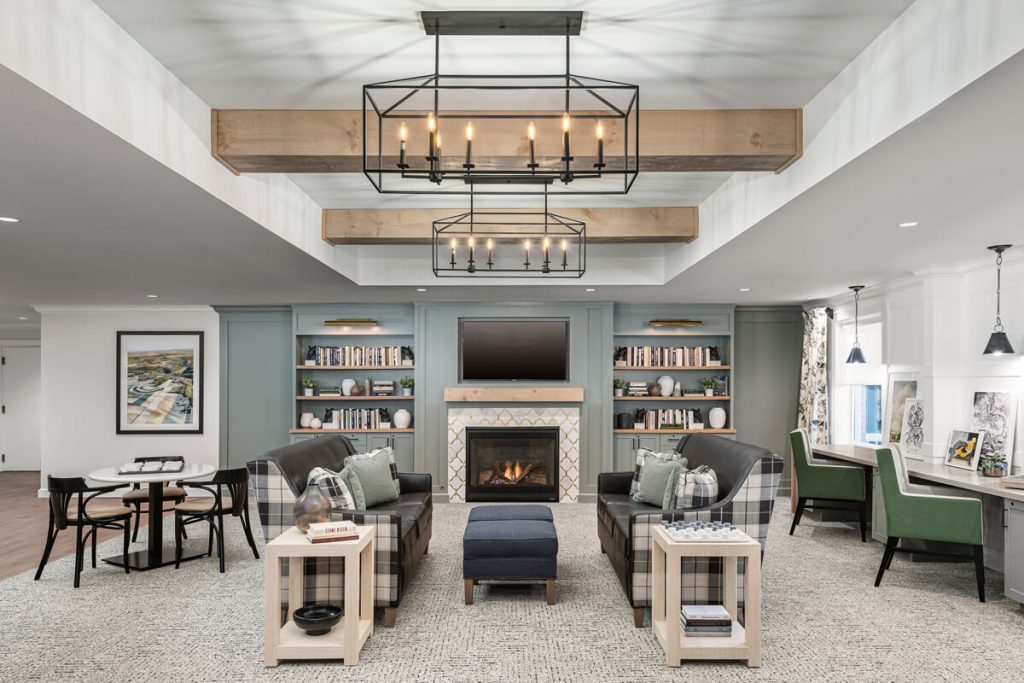 Comfortable Living Area in Richmond Place Community Cozy living area in a senior living community with fireplace, bookcases, seating, and desks.