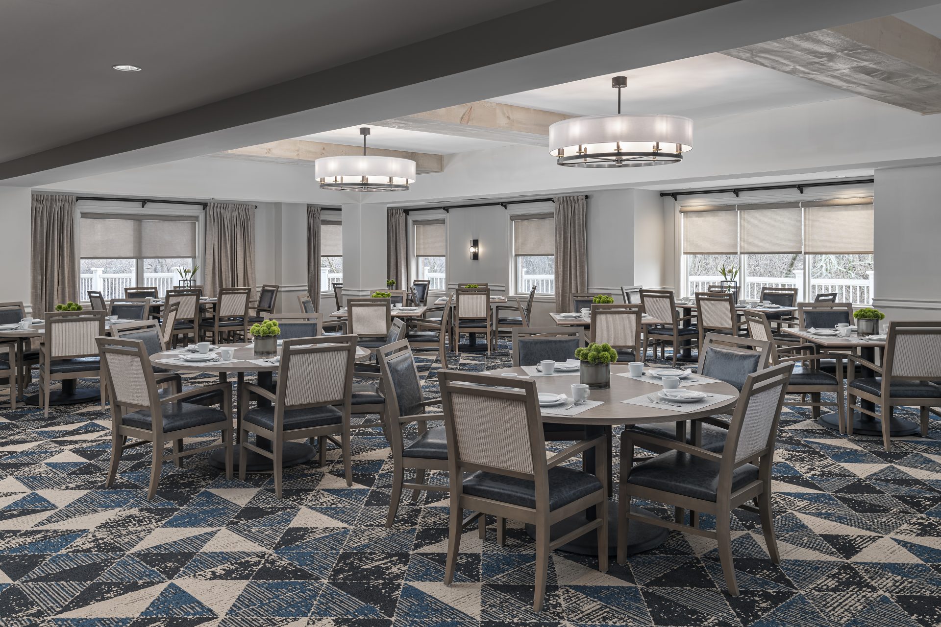 Elegant dining area with multiple tables and chairs in a senior living community.
