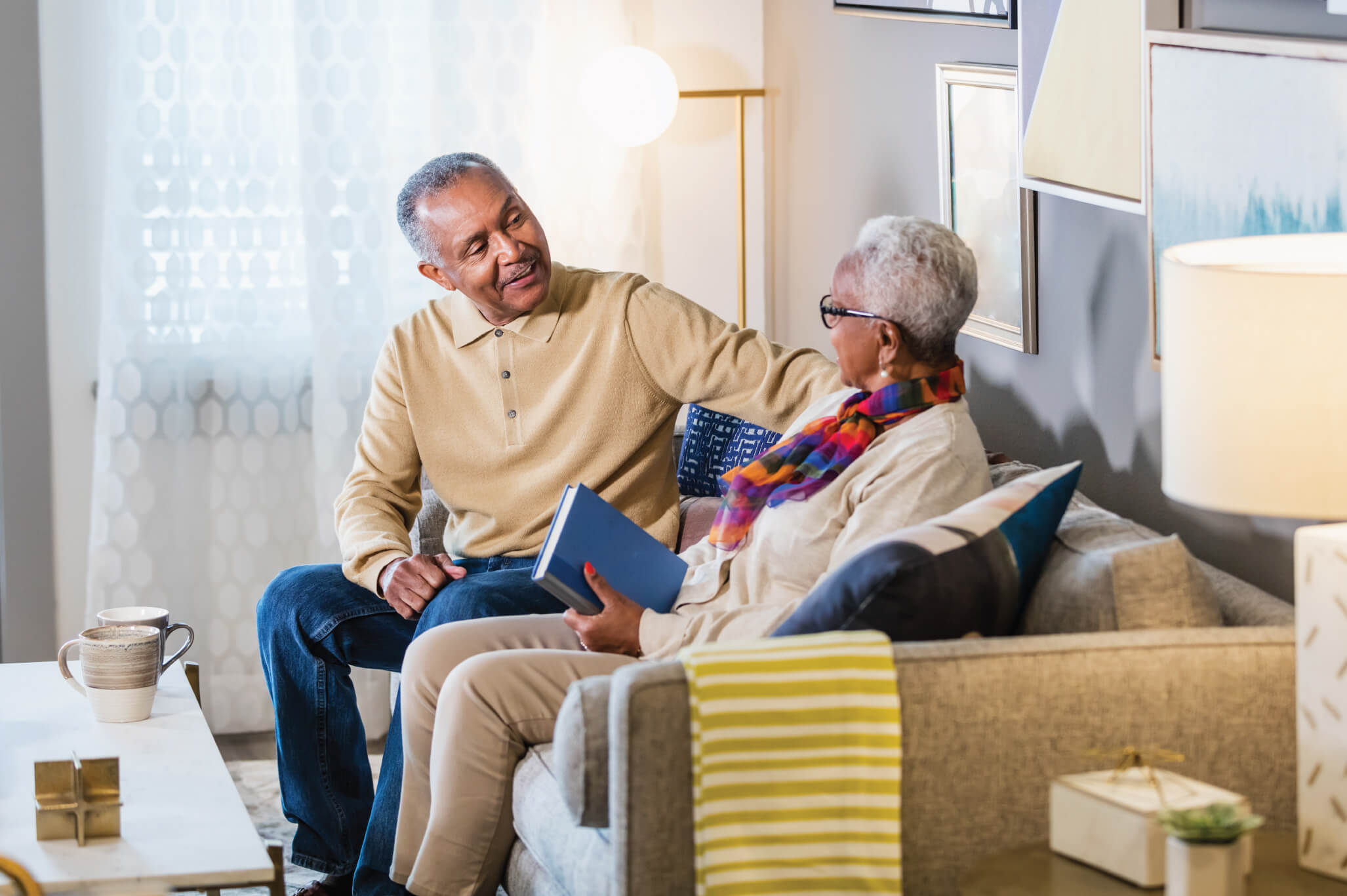 Seniors talking to one another on their living room sofa