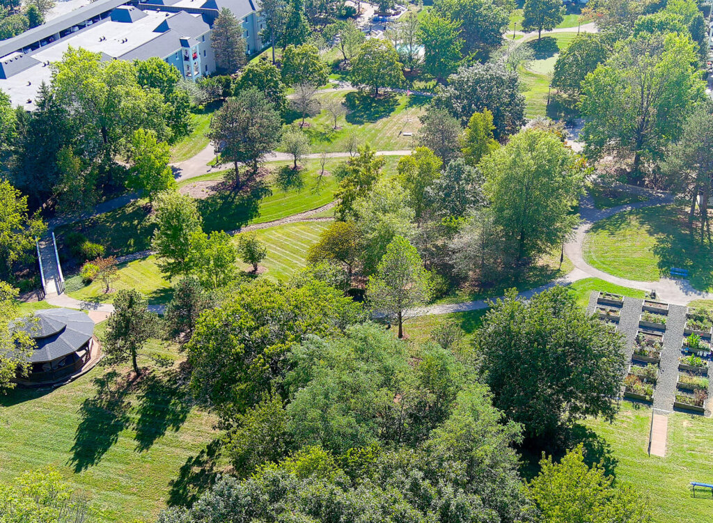 Aerial view of a senior living community with lush green gardens and pathways.