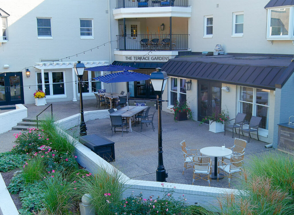 Outdoor patio with tables and chairs at a senior living community.