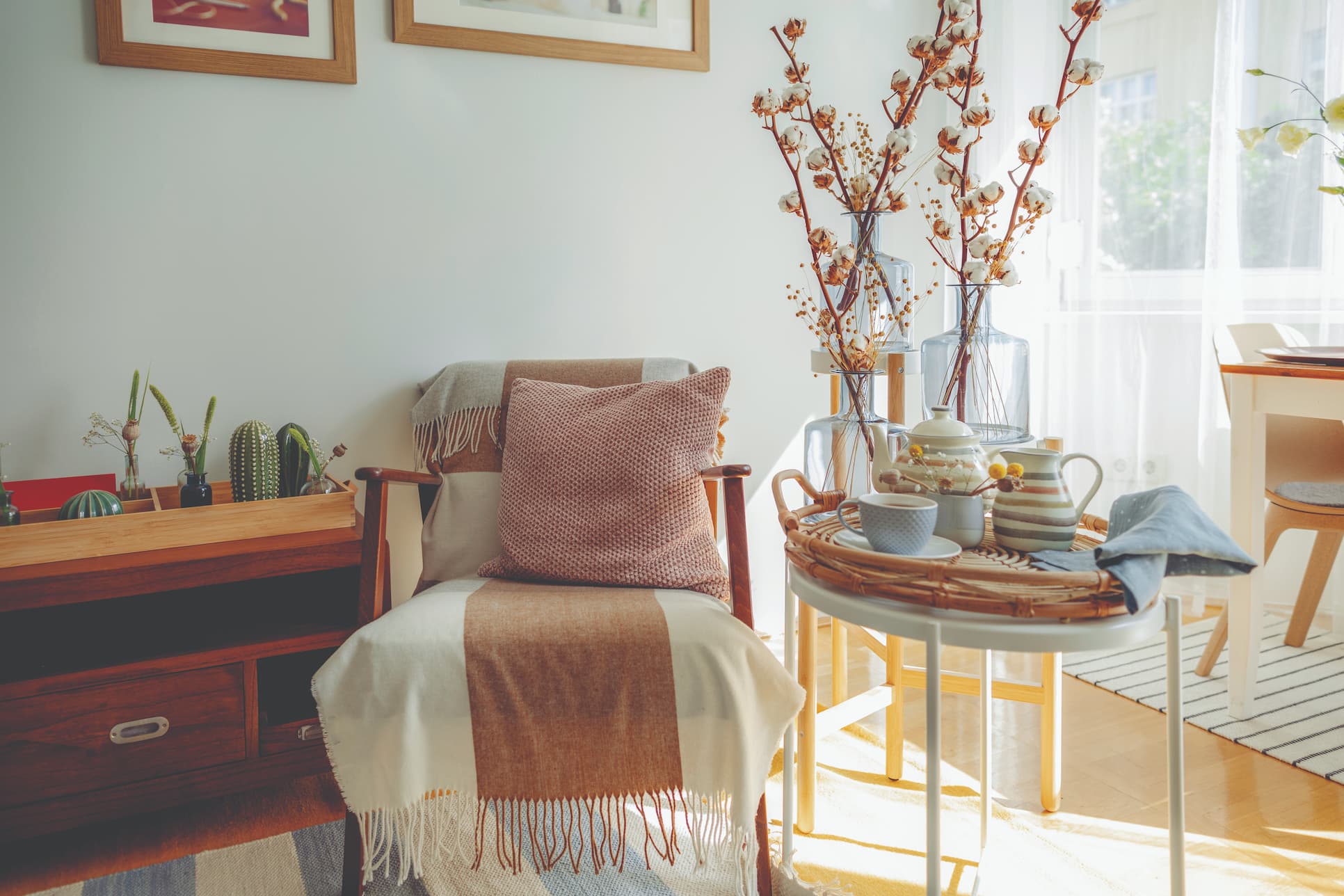 cozy chair in living room with blankets and a side table with tea