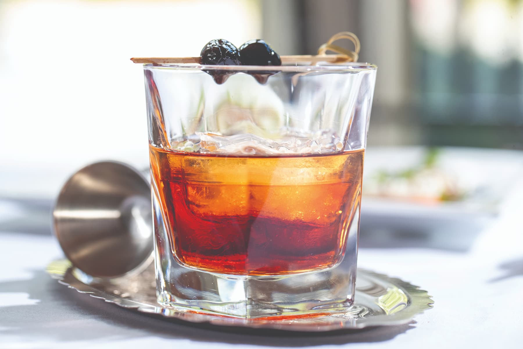 glass-of-bourbon Glass of bourbon on a silver plate